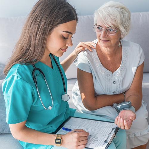 Nurse using pre-printed forms and documents with a patient in a home healthcare setting
