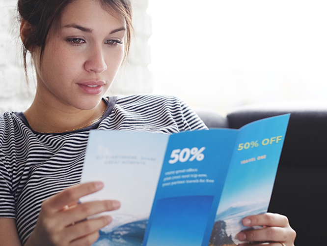 Woman reading full-color trifold brochure printed on high-quality paper stock