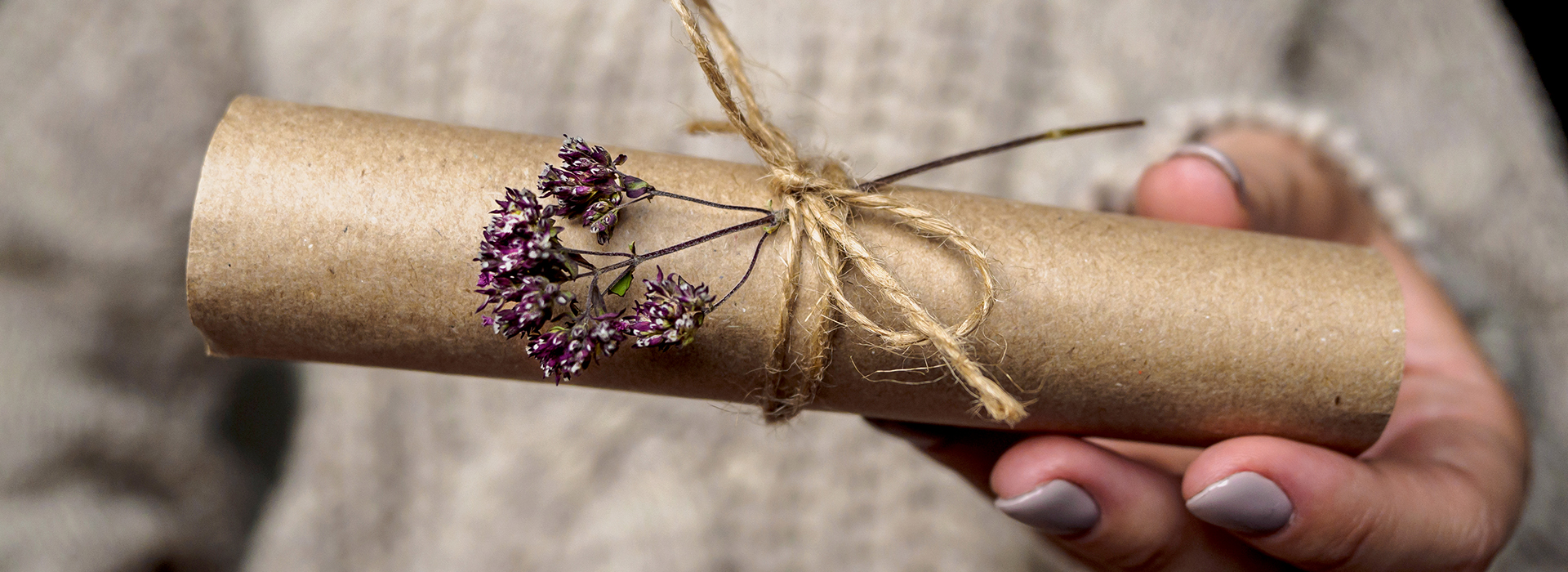 Woman giving custom wrapped gift with flowers for the holidays